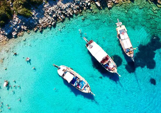 Turkuaz bir koyda demirlemiş ahşap guletler, Bodrum mavi yolculuk